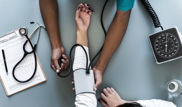 imagem de um médico verificando a pressão do paciente