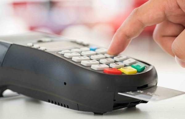 Mão usando máquina de cartão de crédito
