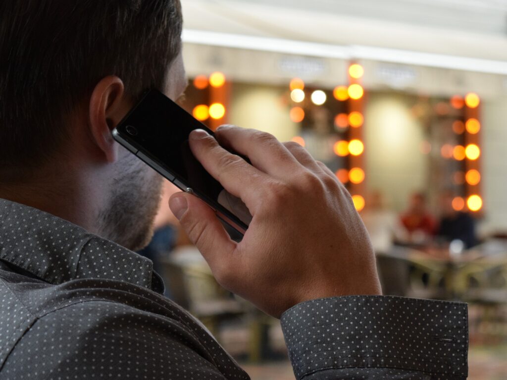 Homem falando no celular em um lugar público