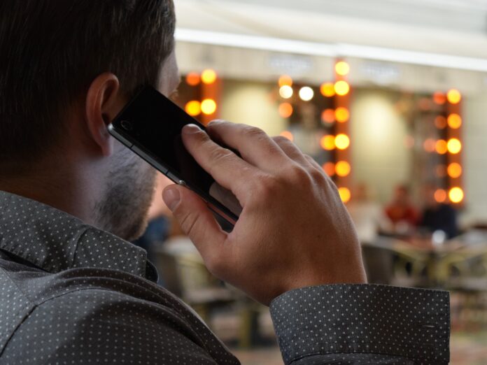 Homem falando no celular em um lugar público