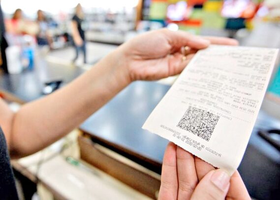 pessoas segurando uma nota fiscal após a compra
