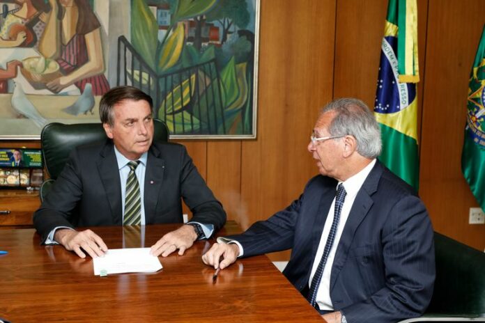 bolsonaro-guedes-foto carolina antunes Presidente Jair Bolsonaro e Ministro da Saúde Paulo Guedes em uma mesa conversando