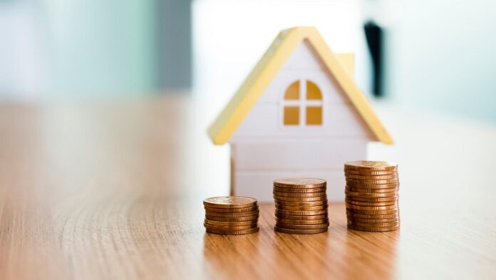 LCI-e-Fundos-imobiliarios-1 Casa de miniatura com três fileiras de moedas em uma mesa de madeira