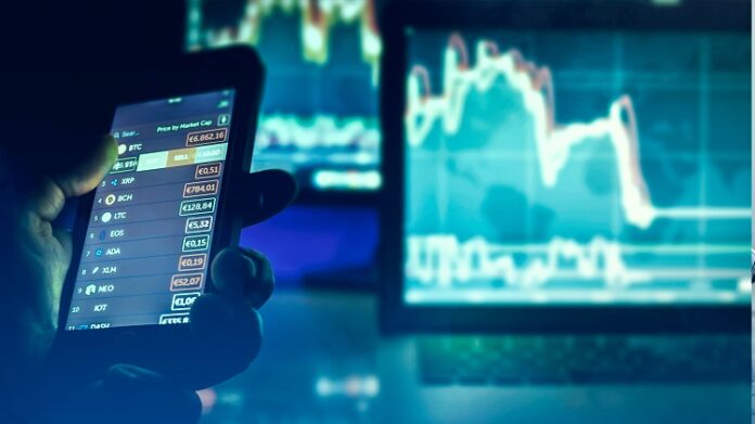 Day Trade Pessoa acessando investimentos no celular e computador, que exibem gráficos