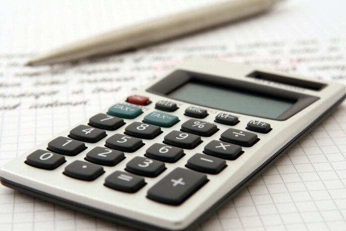 Calculadora em um papel escrito com caneta ao lado