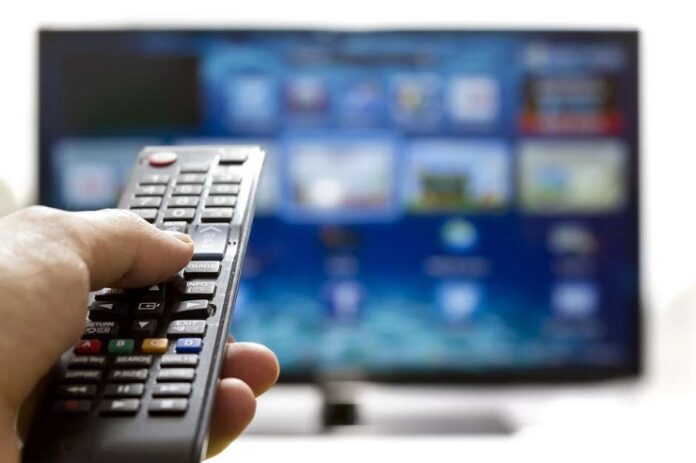 melhores filmes Pessoa usando controle remoto e uma tv grande ao fundo