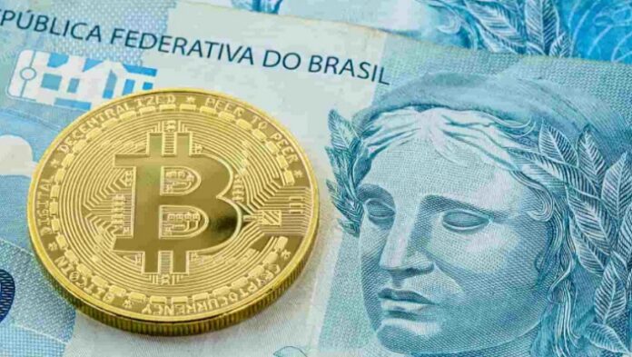 Criptomoeda Bitcoin em cima de uma nota de 100 reais