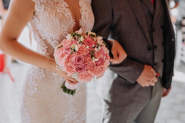 casamento noivos recebendo a benção do casamento com a mulher segurando o buquê