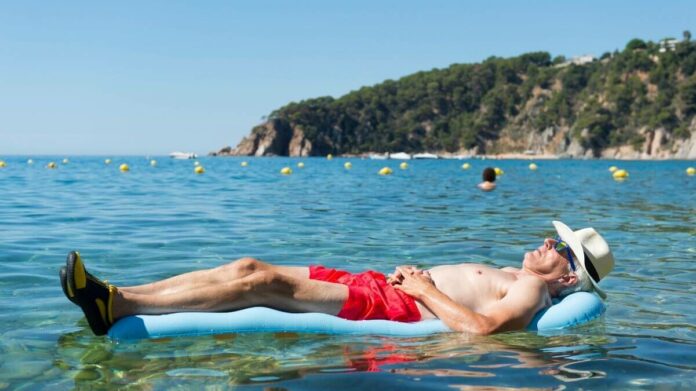 idoso aposentado descansa em boia no mar