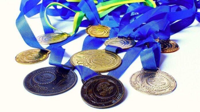 Medalhas dos Jogos Paralímpicos de Tóquio espalhadas sobre superfície branca