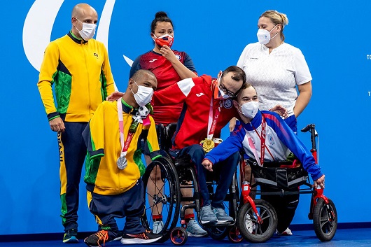 Atletas vencedores da natação nos Jogos Paralímpicos de Tóquio 2020 sorriem e exibem medalhas no pescoço