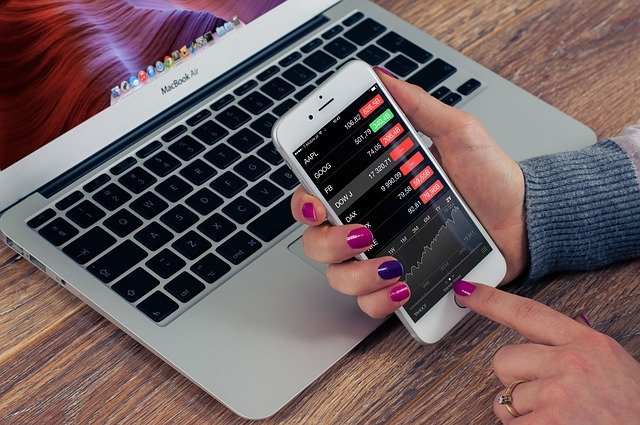 Empreendedor utiliza celular em frente a computador