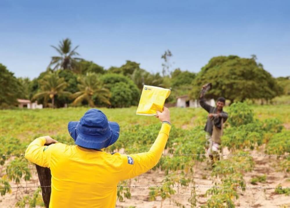 Entregador dos Correios entrega pacote para homem em área Rural