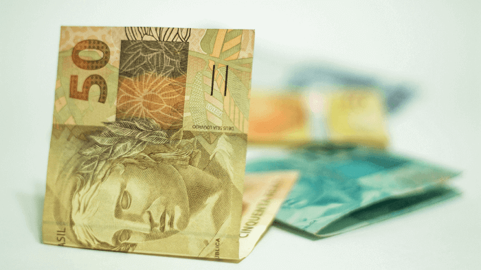 Notas do Real Brasileiro espalhadas sobre mesa branca