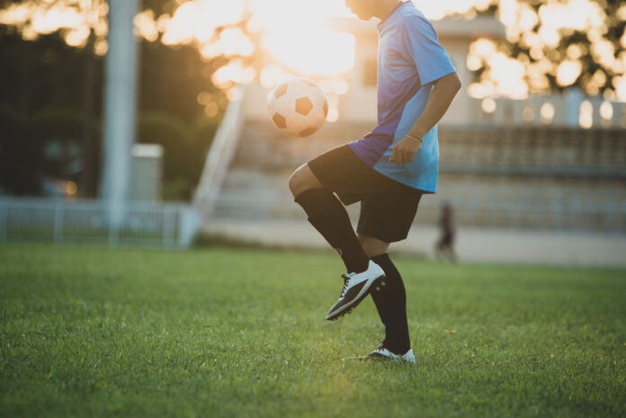 jogador de futebol fazendo embaixaidinhas em um campo de futebol