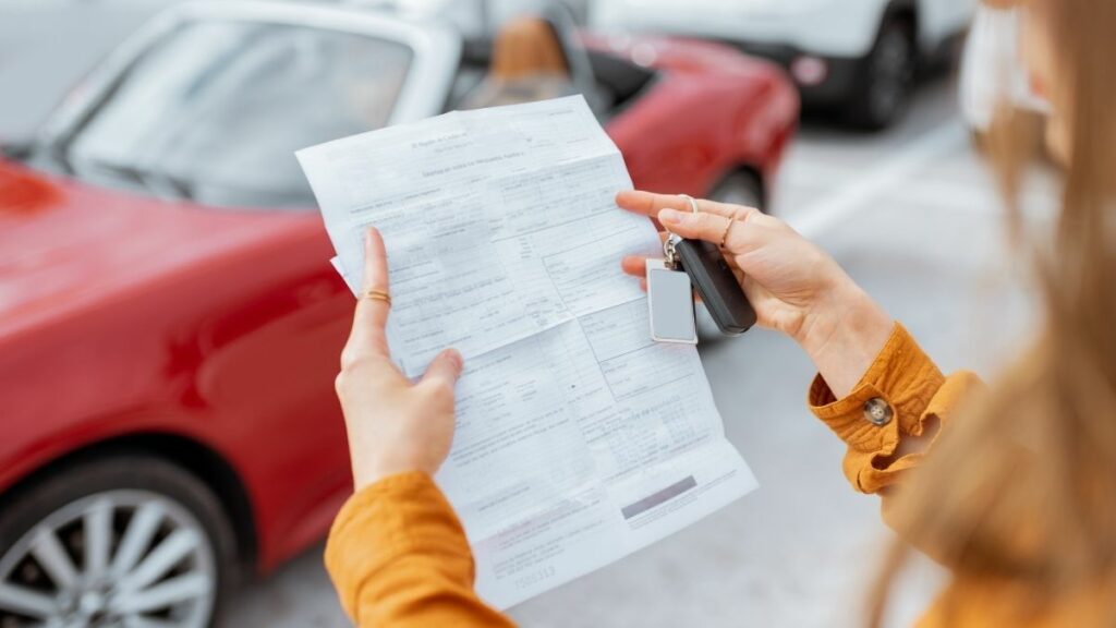Mulher segura um contrato de leasing e a chave de um carro