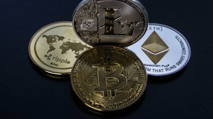 Quatro criptomoedas sobre superfície preta espelhada