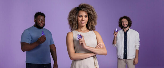 Três pessoas seguram um diamante roxo simulando a BDR do IPO do Nubank