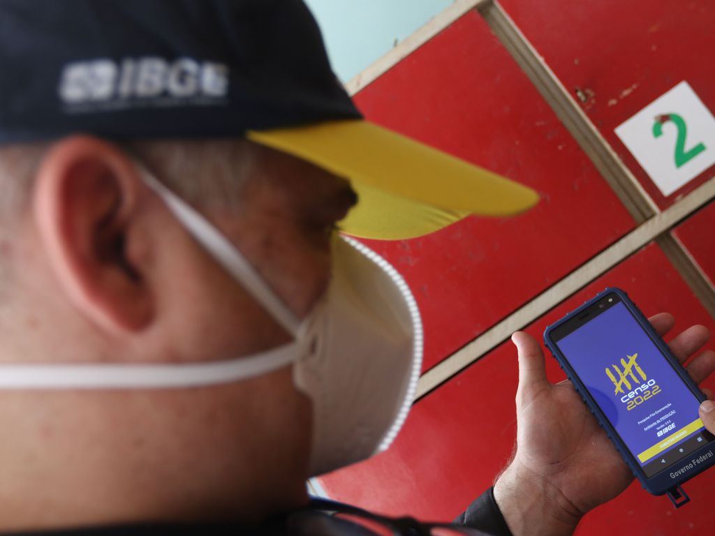 Recenseador do IBGE manuseia aparelho para coleta de dados nos domicílios