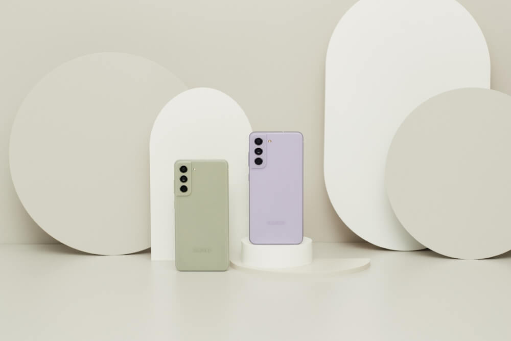 Dois celulares do modelo Galaxy S21 FE apoiados sobre um fundo claro