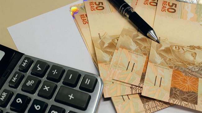 calculadora com notas de cinquenta reais ao lado