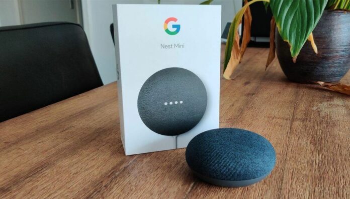 Google Assistente sobre uma mesa de madeira com a embalagem da Google atrás