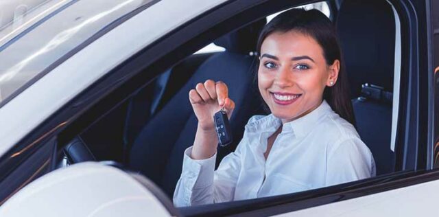 mulher seguranndo a chave de um carro