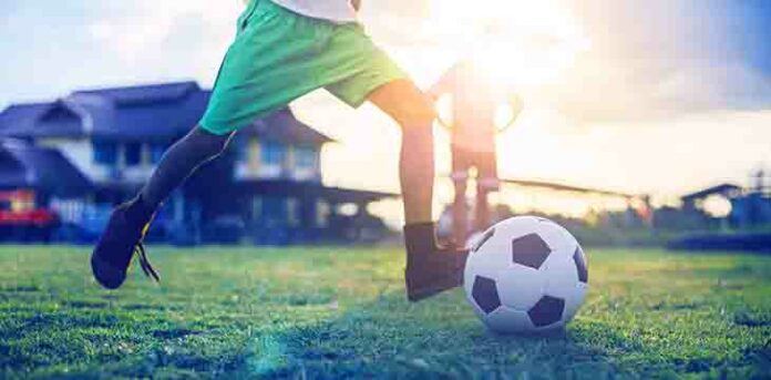 menino jogando futebol