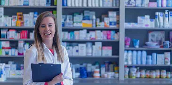 farmacia6 Mulher sorrindo com jaleco em uma farmácia