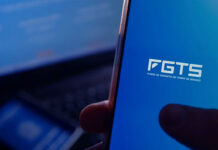 Nome sujo bloqueia o saldo do FGTS? Entenda! Pessoa segura celular aberto no aplicativo FGTS