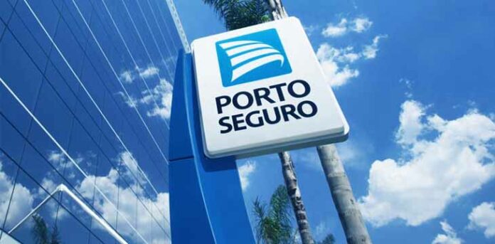 janela espelhada e o logo da Porto Seguro no meio de um céu com nuvens