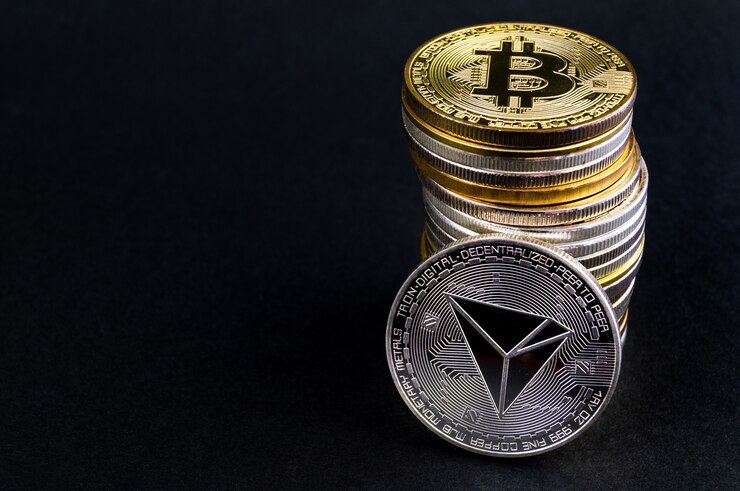 Uma pilha de criptomoedas com um Bitcoin no topo e uma Tron (TRX) apoiada na frente