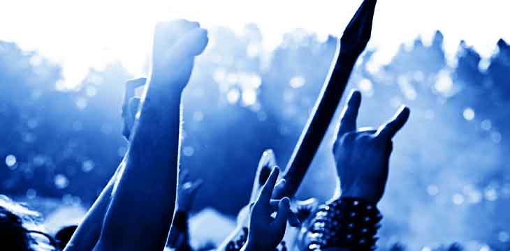 pessoas com as mãos levantadas em um show de rock