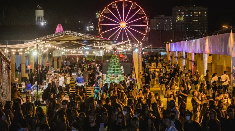 Imagem aérea do Rio Gastronomia com pessoas em frente ao palco e a roda gigante ao fundo