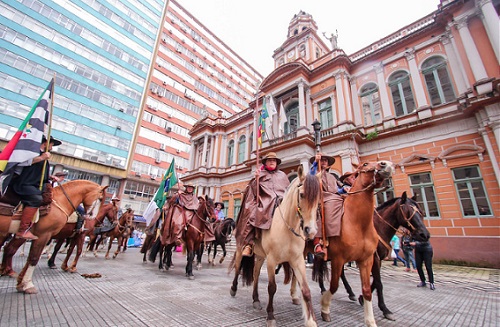 pessoas montadas em cavalos no centro de Porto Alegre