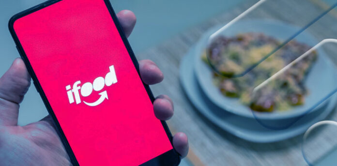 Pessoa segurando celular aberto no Ifood
