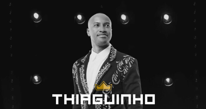 Pôster do cantor Thiaguinho em preto e branco com luzes de camarim ao fundo